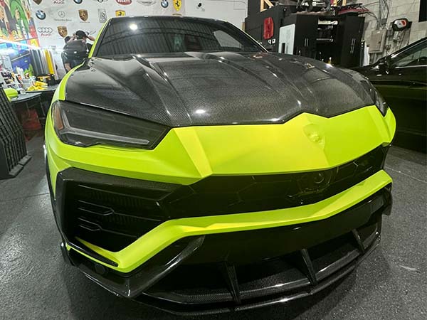 Vinyl wrap installation on a Lamborghini SUV by Marine Wraps, offering a sleek, custom look.